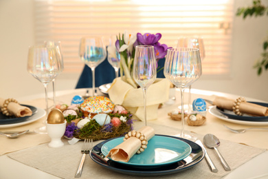 Festive Easter table setting with decorated eggs in kitchen