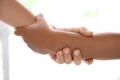 Photo of Children holding hands on light background, closeup. Unity concept