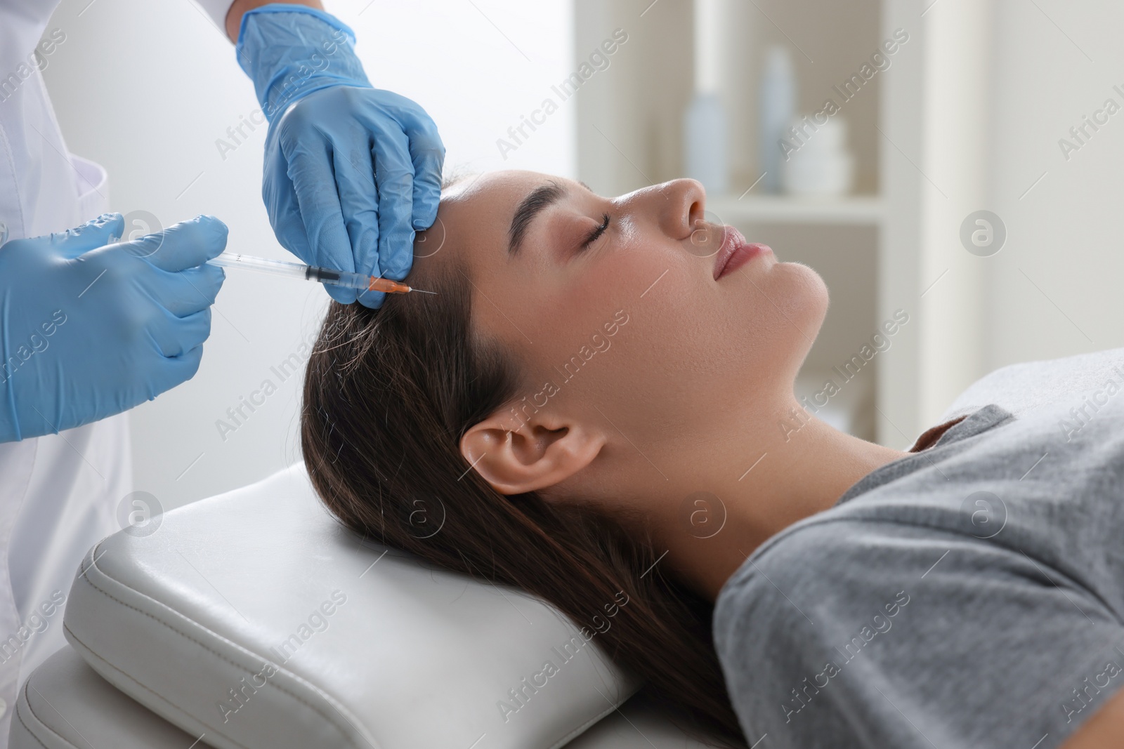 Photo of Trichologist giving injection to patient in clinic, closeup