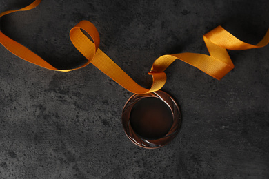Bronze medal on grey stone background, top view. Space for design