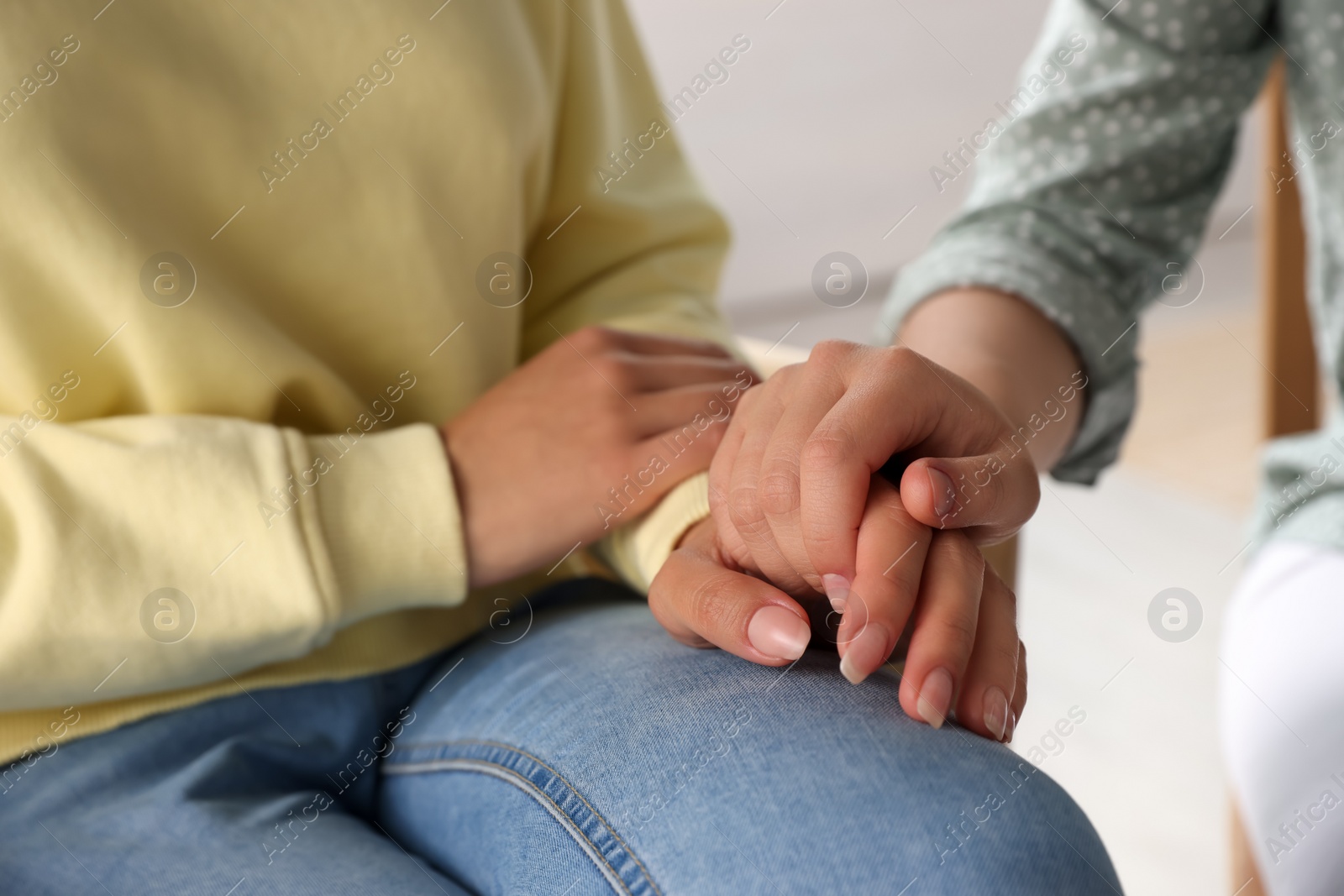 Photo of Psychotherapist holding patient's hand in office, closeup