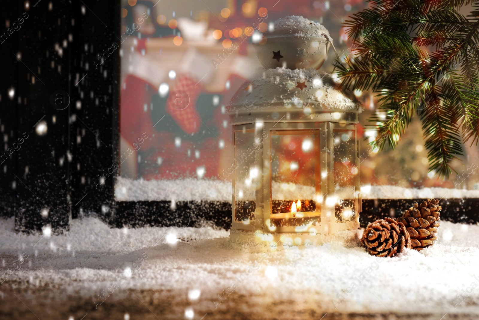 Image of Snow falling onto window sill with Christmas lantern outdoors