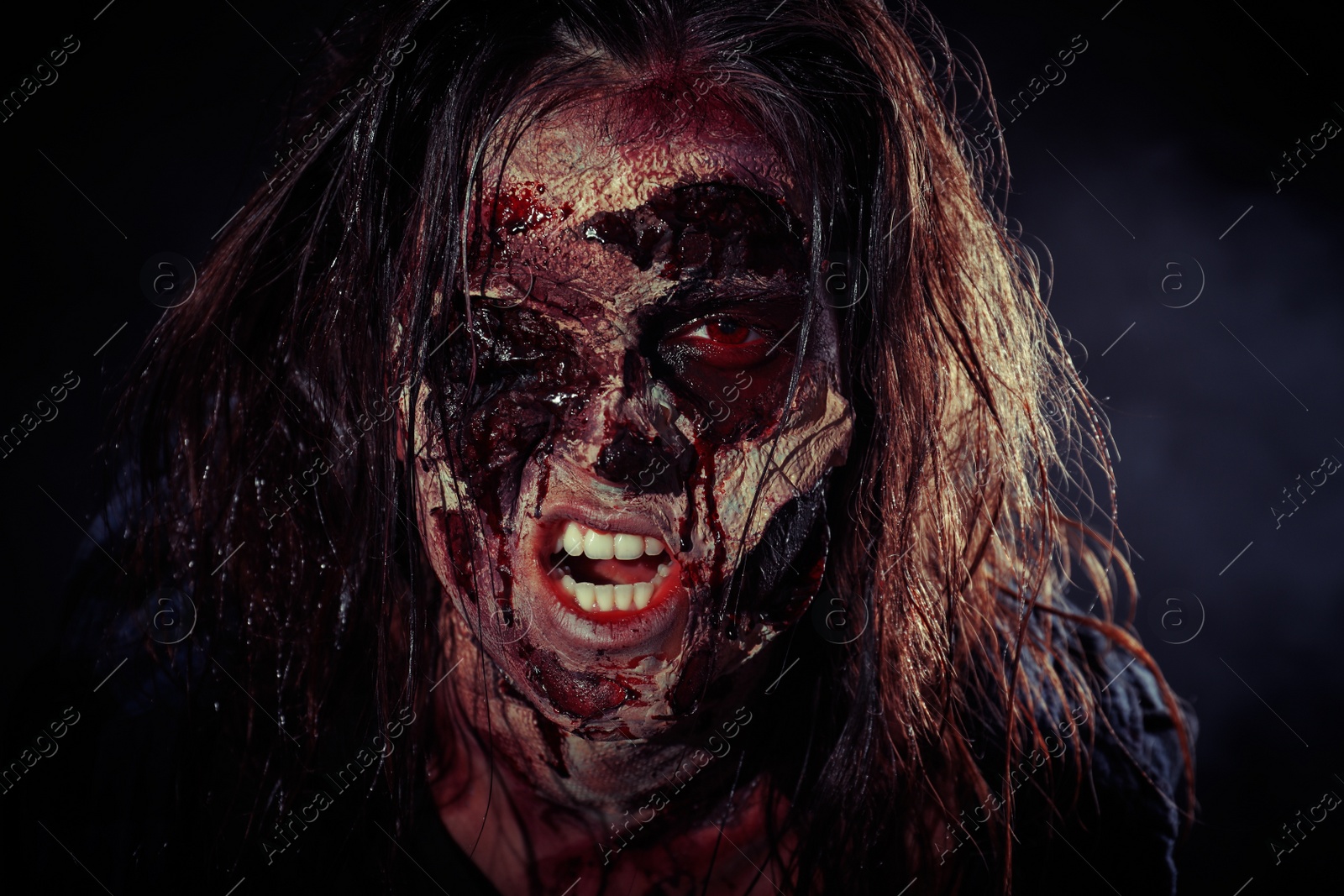 Photo of Scary zombie on dark background, closeup. Halloween monster