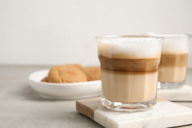 Photo of Glasses with delicious latte macchiato on white table, space for text