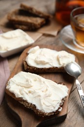 Photo of Bread with cream cheese on wooden table