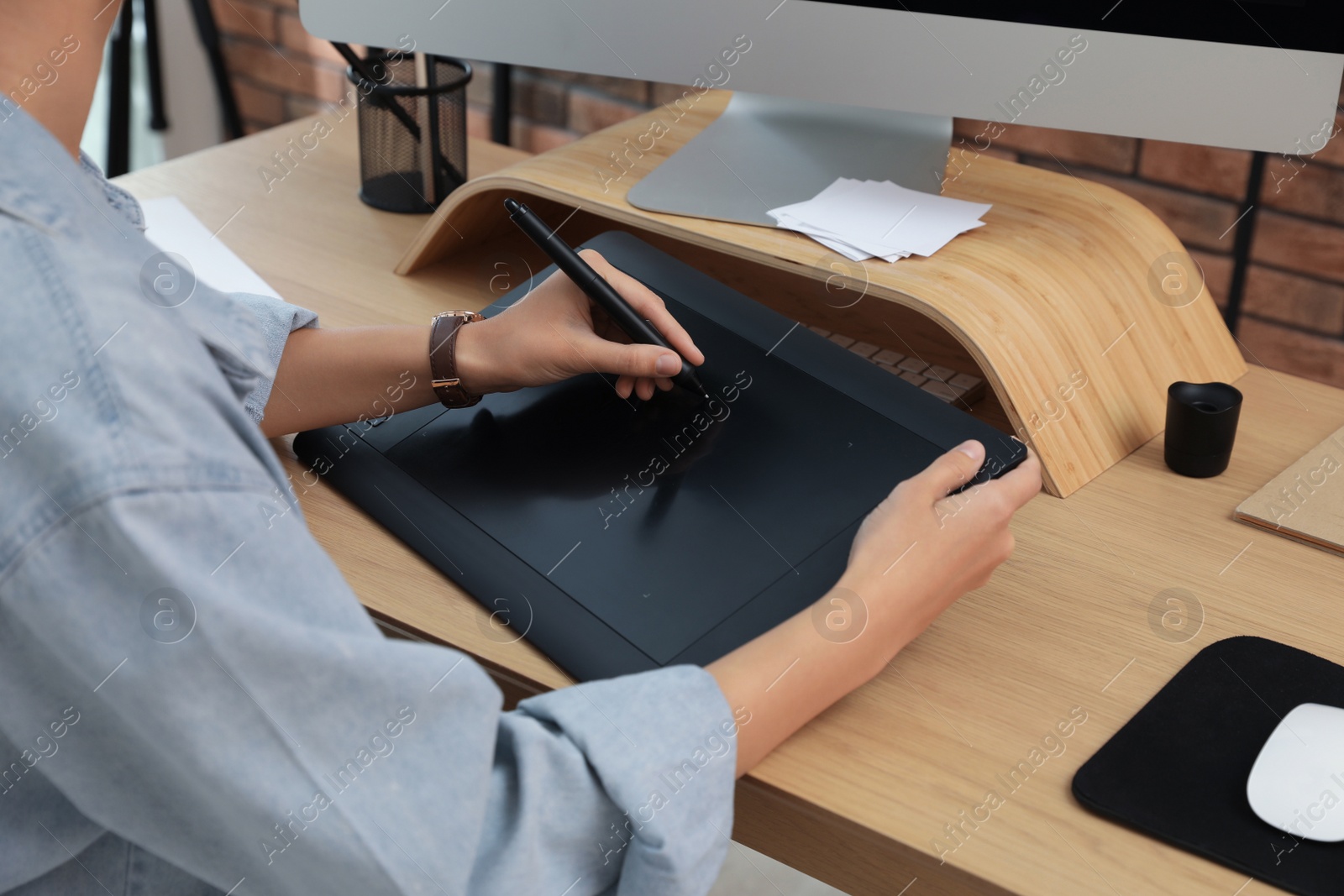 Photo of Professional retoucher working on graphic tablet at desk, closeup