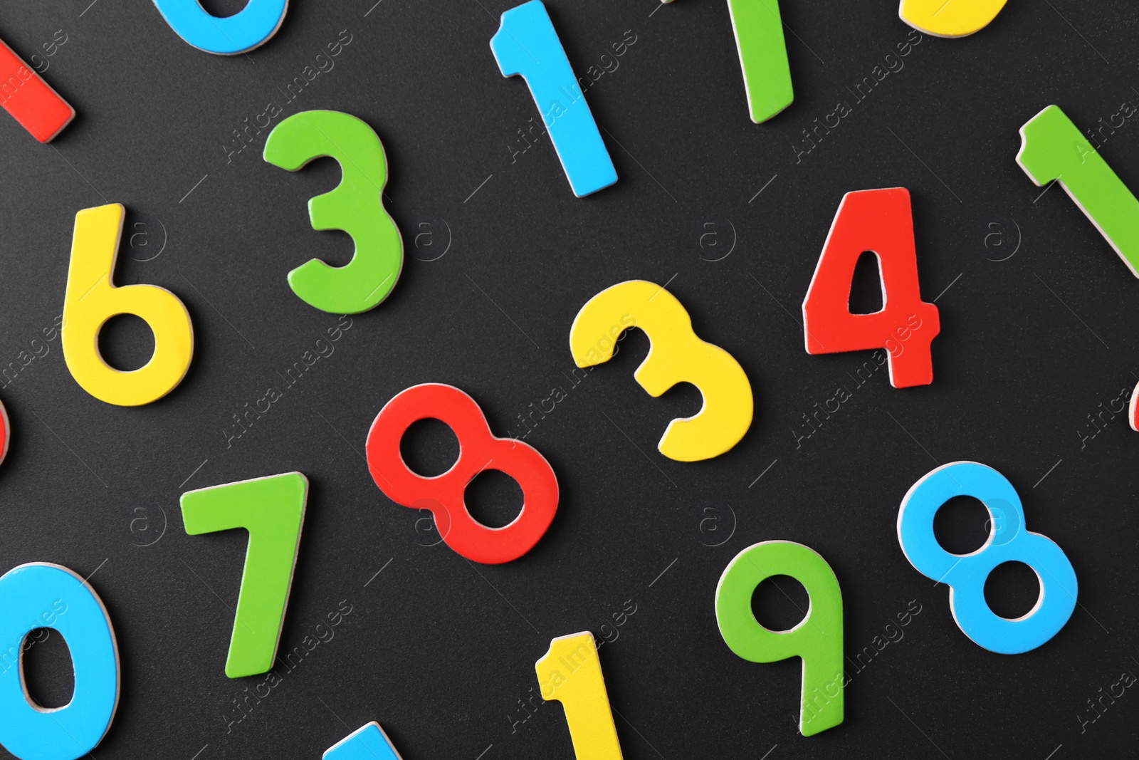 Photo of Colorful numbers on black background, flat lay