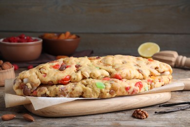Photo of Unbaked Stollen with candied fruits and raisins on wooden table
