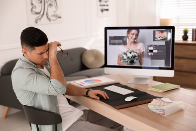 Tired retoucher at workplace with computer in office