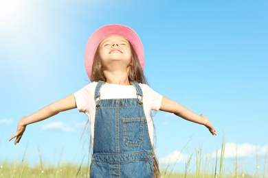 Photo of Cute little girl outdoors on sunny day. Child spending time in nature