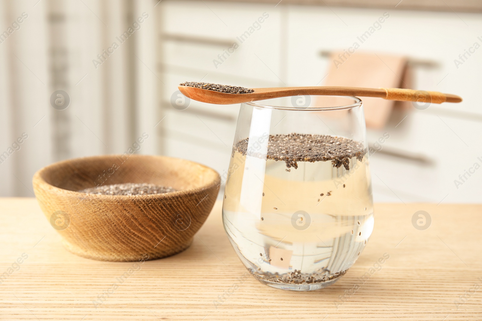 Photo of Composition with glass of water and chia seeds on table against blurred background