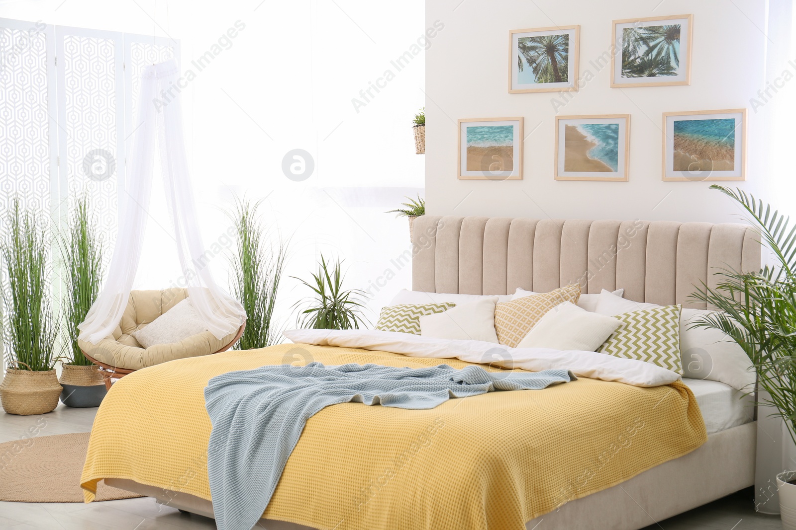Photo of Stylish room interior with large comfortable bed and beautiful paintings