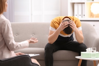 Psychotherapist working with young man in office