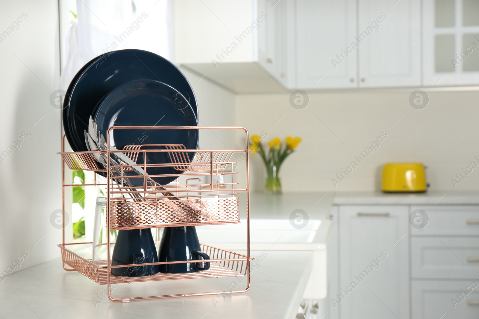 Photo of Drying rack with clean dishes on countertop in kitchen. Space for text