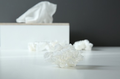 Used paper tissue and holder on white table, closeup