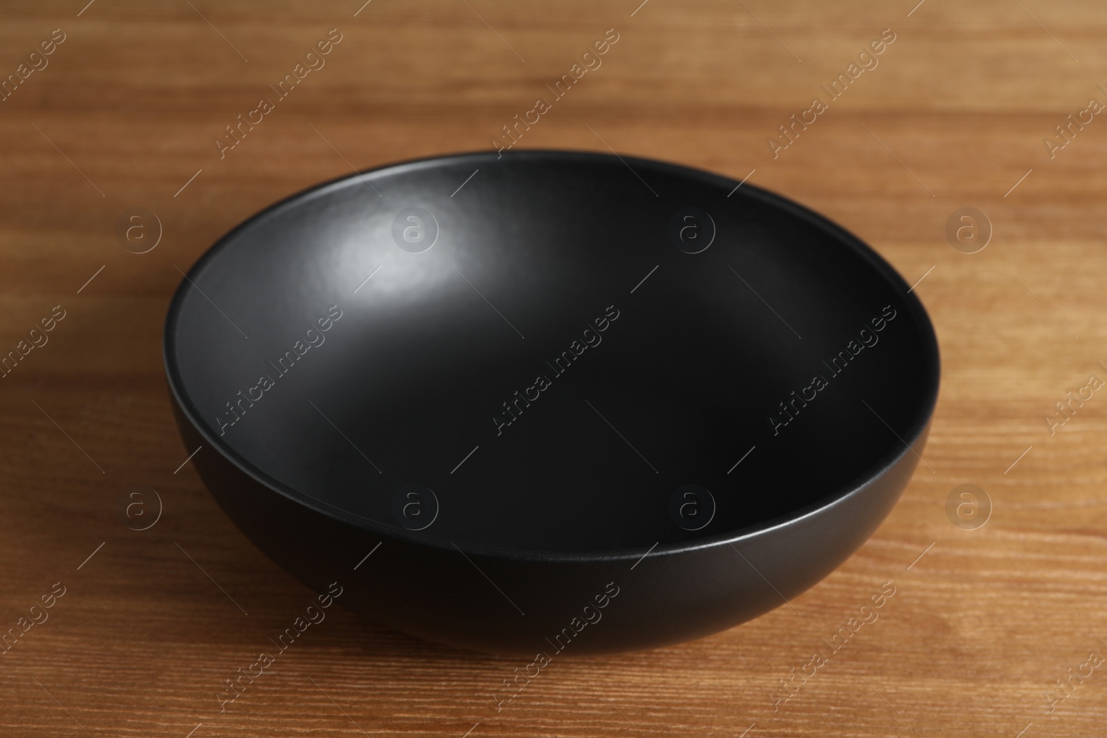 Photo of Elegant new empty bowl on wooden table