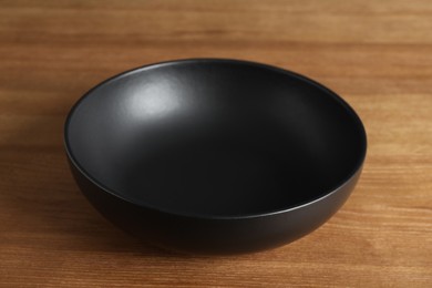 Photo of Elegant new empty bowl on wooden table