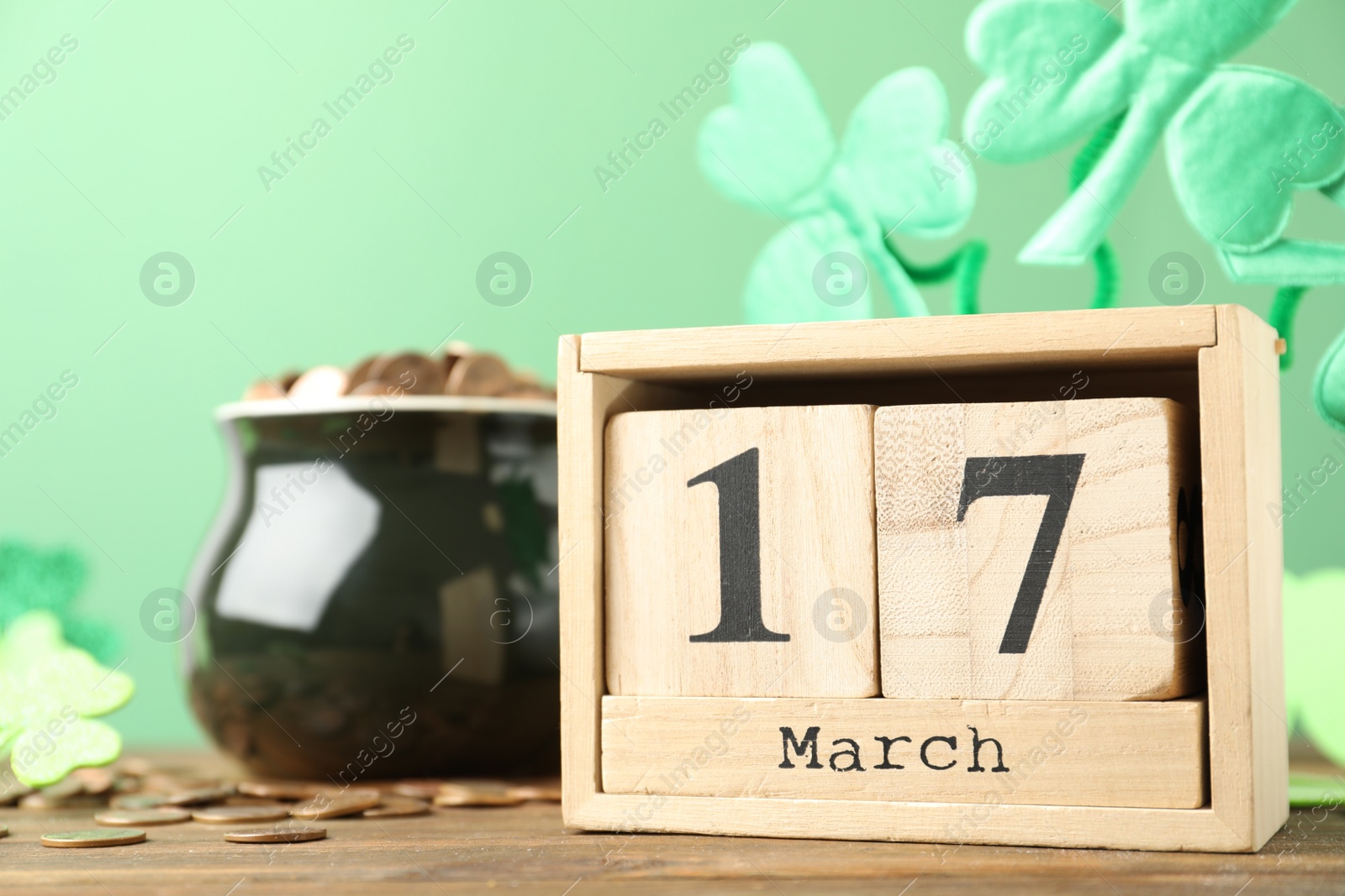 Photo of Composition with block calendar on wooden table. St. Patrick's Day celebration