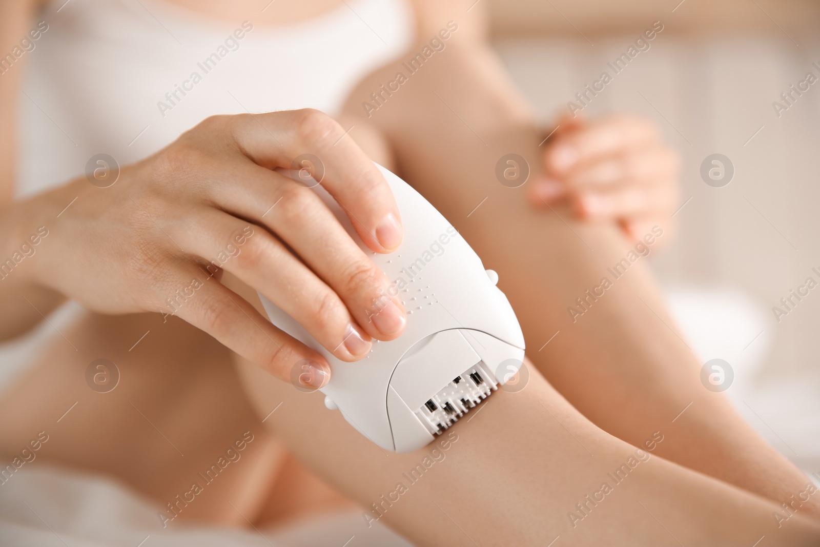 Photo of Woman doing leg epilation procedure indoors, closeup