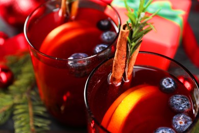 Aromatic Sangria drink in glasses, ingredients and Christmas decor on table, closeup