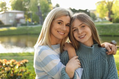 Happy mother with her daughter spending time together in park on sunny day