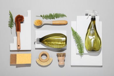 Photo of Flat lay composition with different cleaning supplies on light gray background