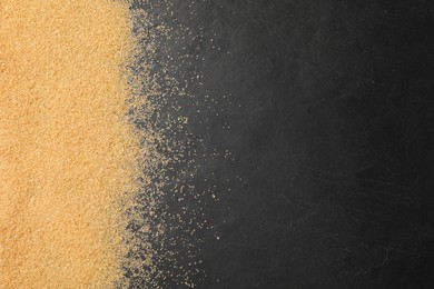 Photo of Brown sugar on black table, top view. Space for text