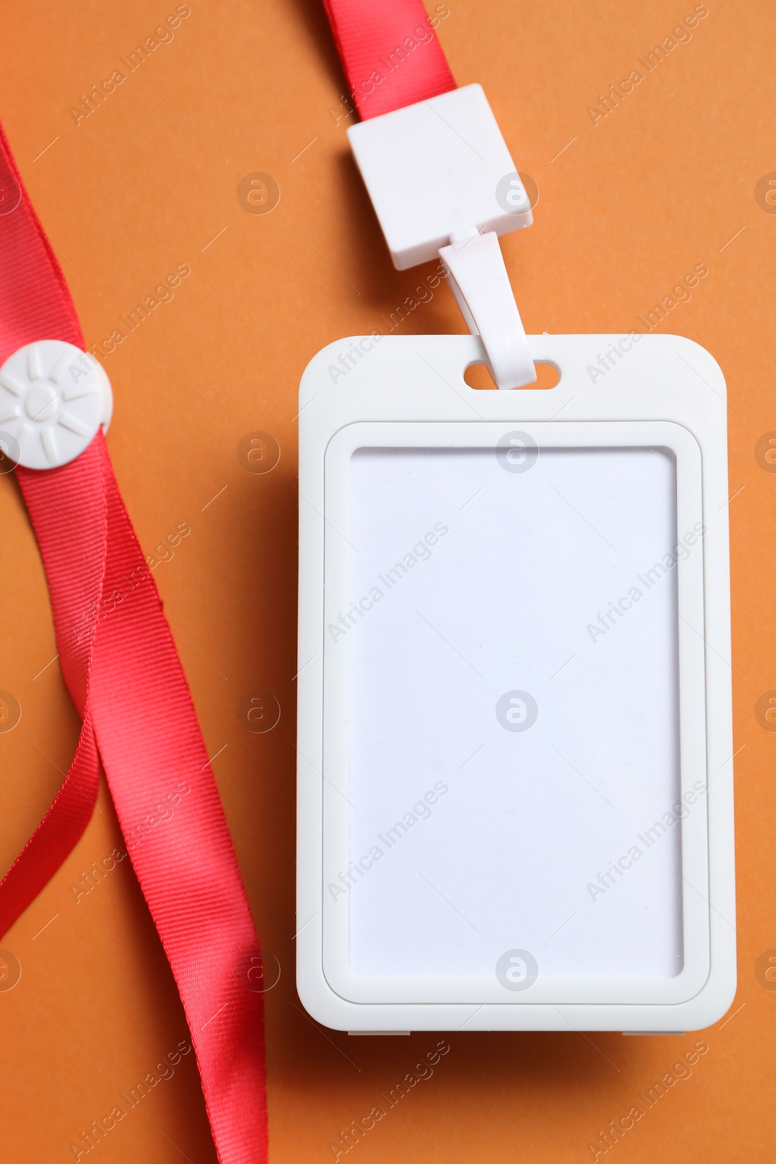 Photo of Blank badge with string on orange background, top view