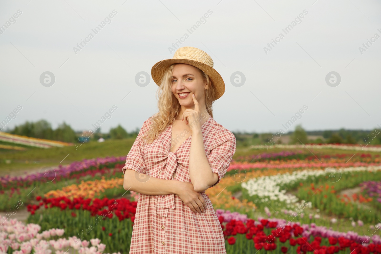 Photo of Happy woman in beautiful tulip field outdoors