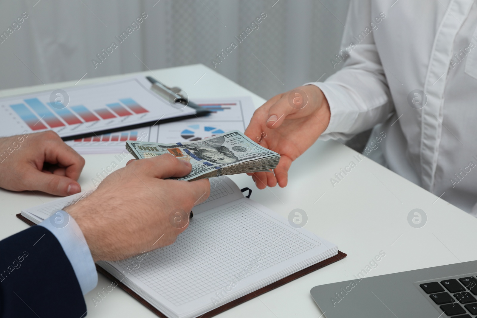 Photo of Cashier giving money to businesswoman at desk in bank, closeup