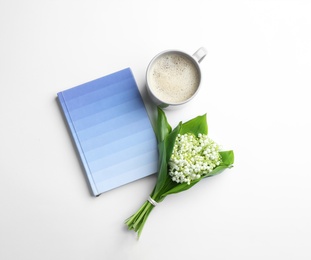 Flat lay composition with notebook, lily of the valley bouquet and coffee on white background