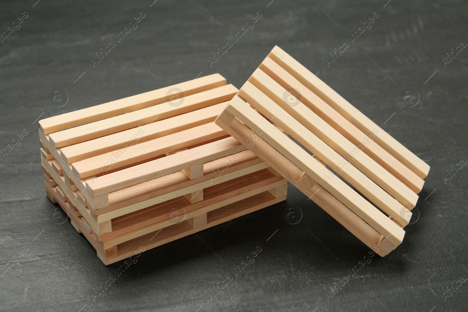 Photo of Many small wooden pallets on black table