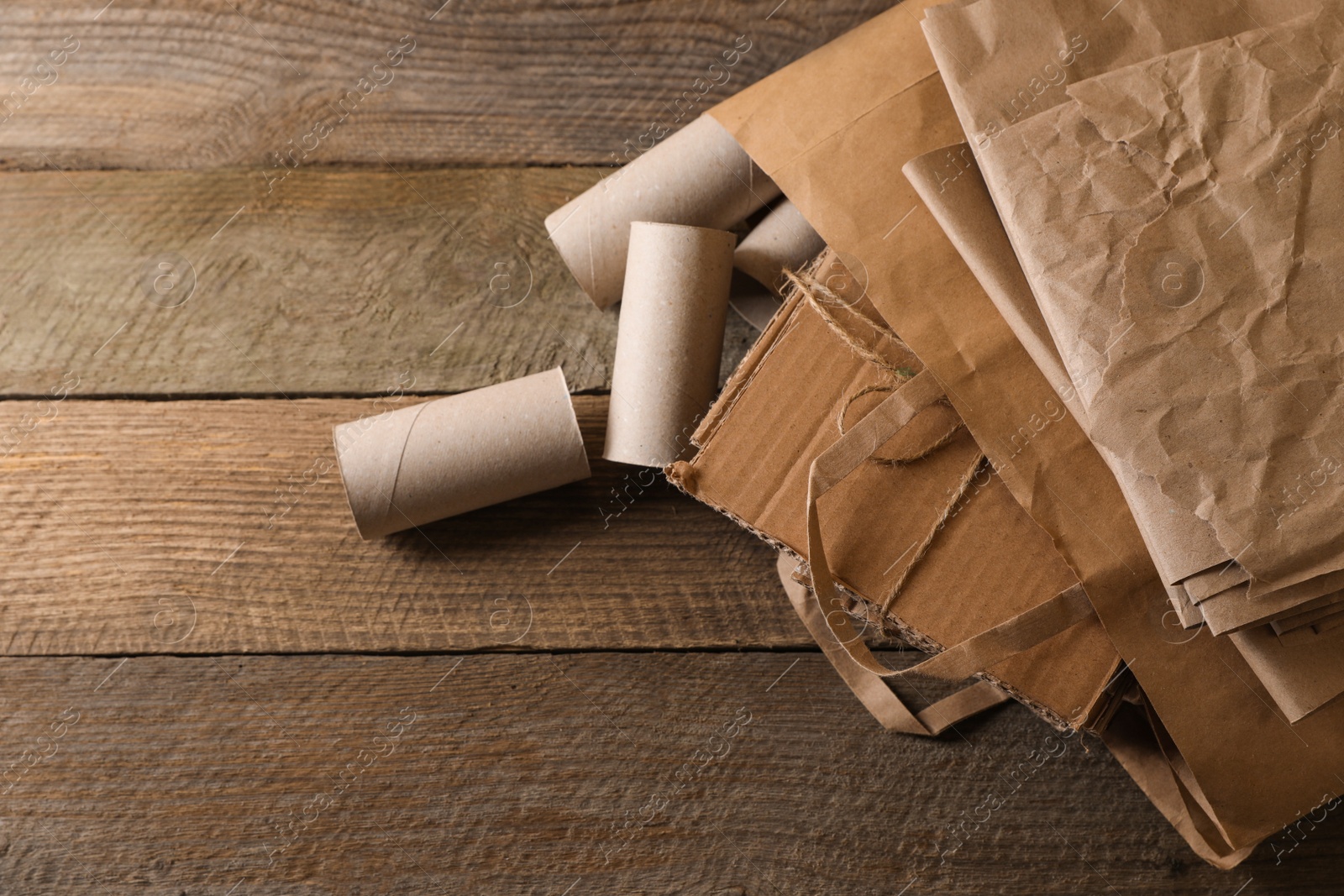 Photo of Different waste paper on wooden table, flat lay. Space for text