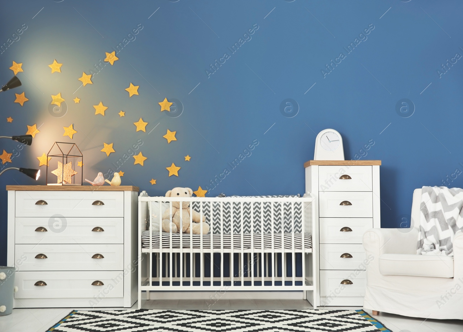 Photo of Baby room interior with comfortable crib and armchair