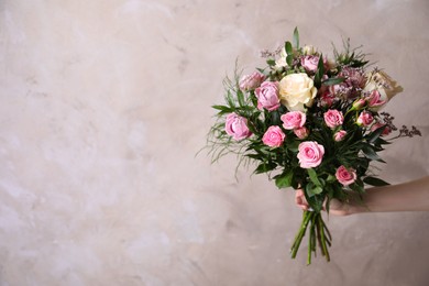 Photo of Woman with bouquet of beautiful roses on beige background, closeup. Space for text