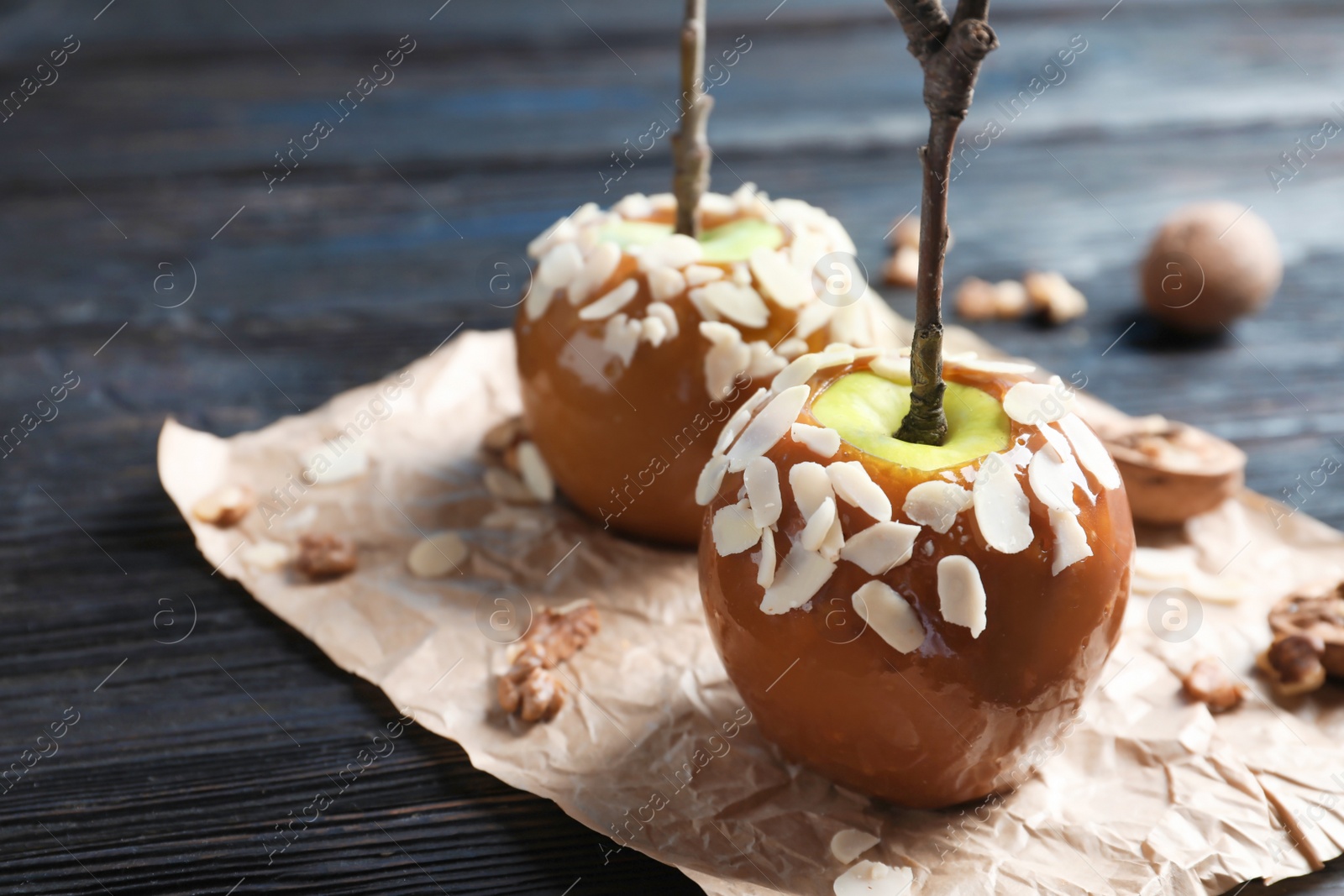 Photo of Delicious caramel apples on wooden background