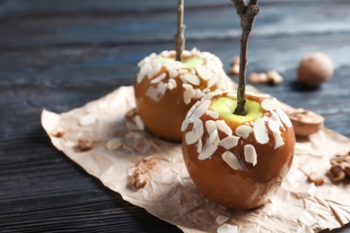Photo of Delicious caramel apples on wooden background