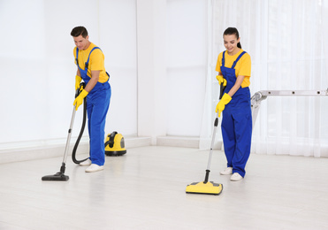 Team of professional janitors cleaning room after renovation