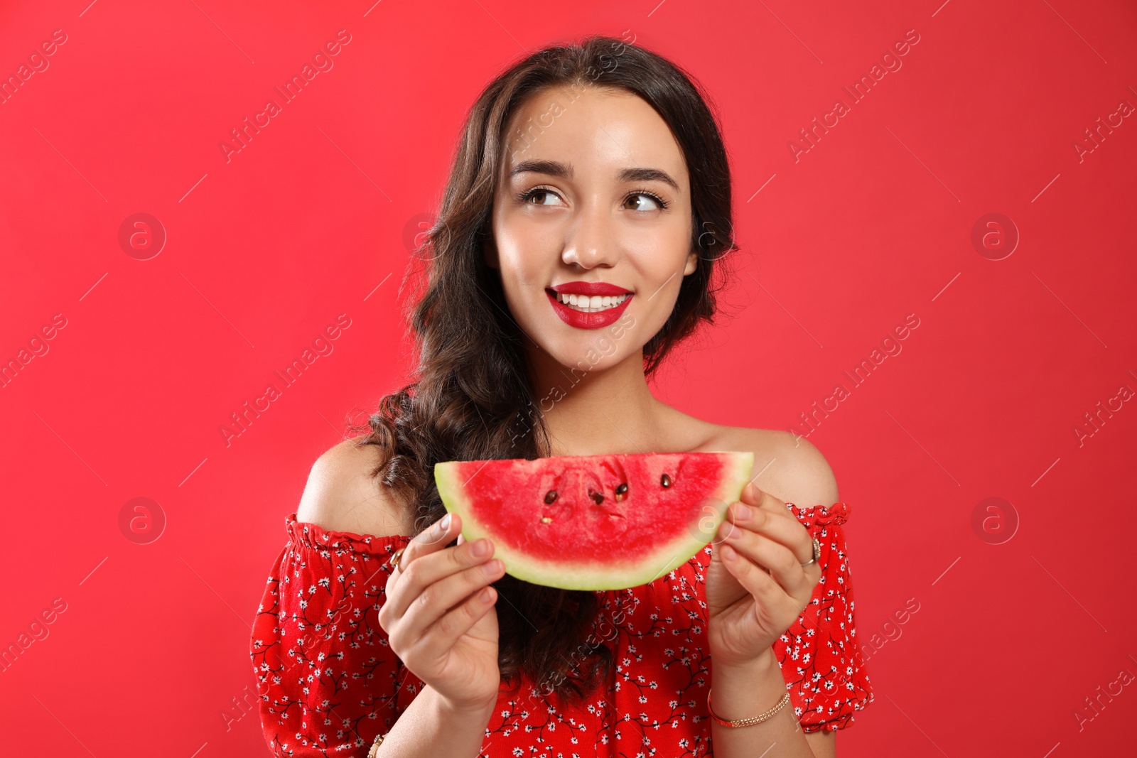 Photo of Beautiful young woman with watermelon on red background