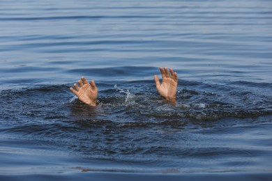 Drowning man reaching for help in sea, closeup