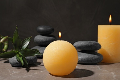 Composition with candles and spa stones on marble table