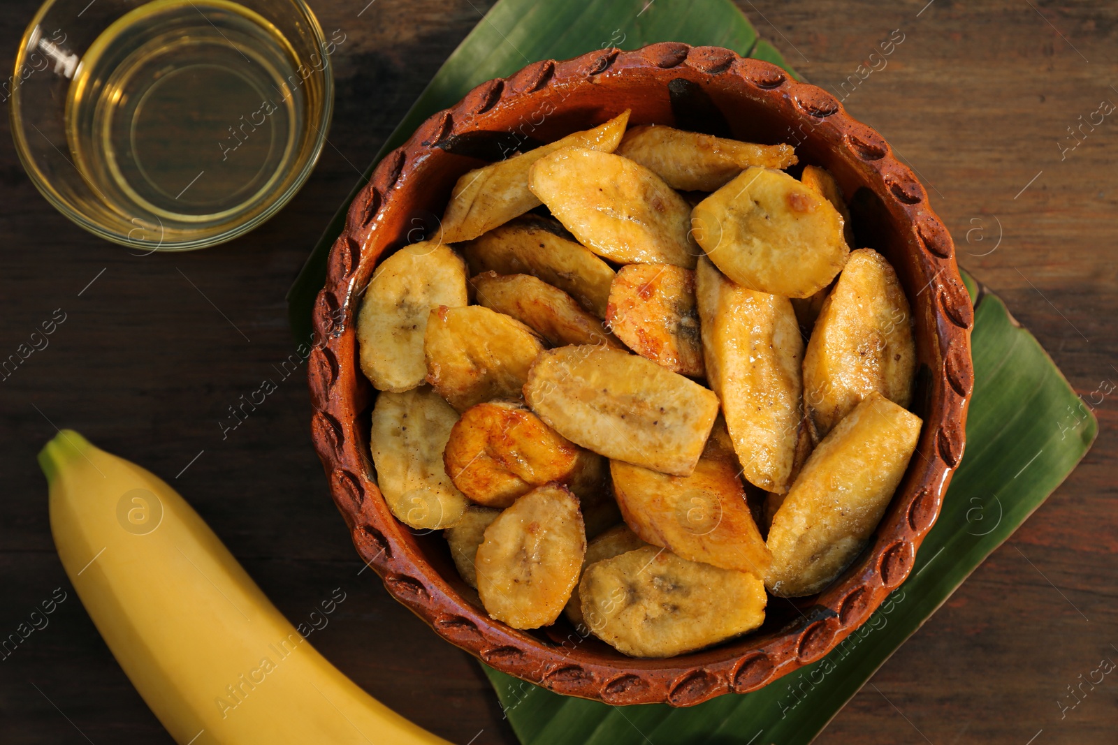 Photo of Flat lay composition with deep fried banana slices on wooden table