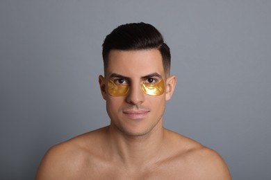 Photo of Man with golden under eye patches on grey background