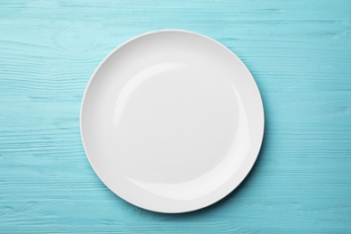 Photo of Stylish ceramic plate on wooden background, top view