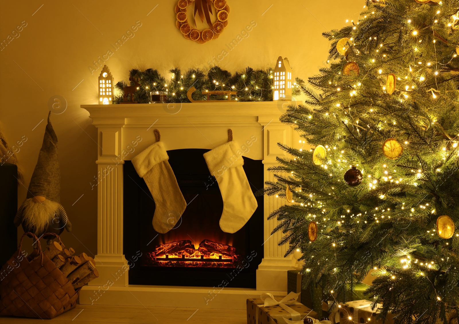 Photo of Stylish fireplace near decorated Christmas tree and accessories in cosy room