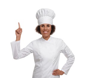 Photo of Happy female chef in uniform pointing at something on white background