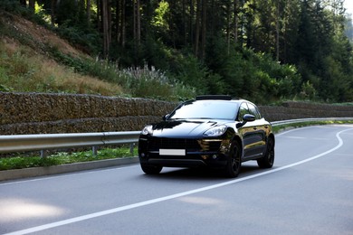 Photo of Picturesque view of asphalt road with modern black car outdoors