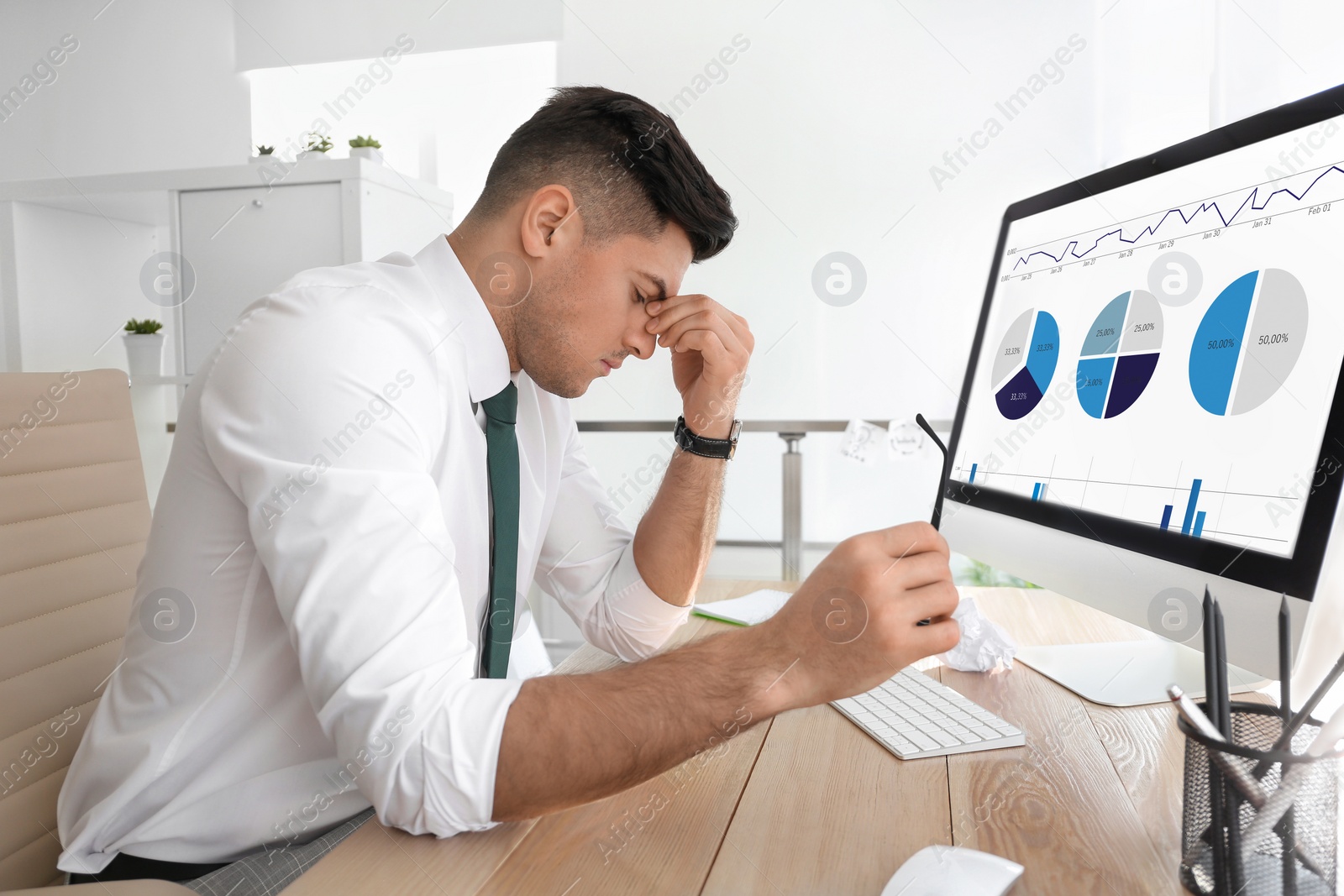 Photo of Businessman stressing out at workplace in office