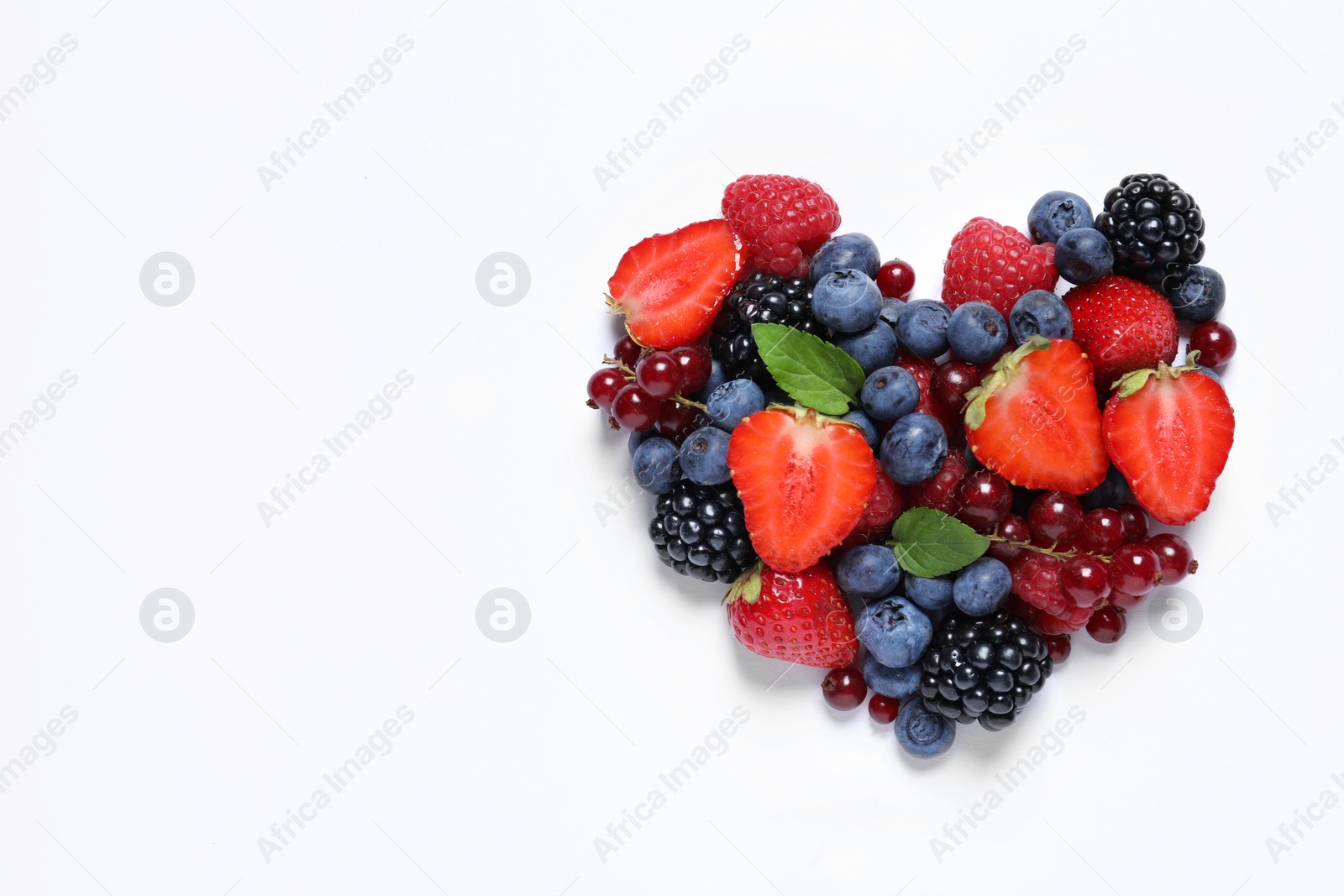 Photo of Heart made of different fresh ripe berries on white table, top view. Space for text