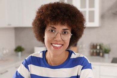 Photo of Portrait of happy young woman with eyeglasses in kitchen